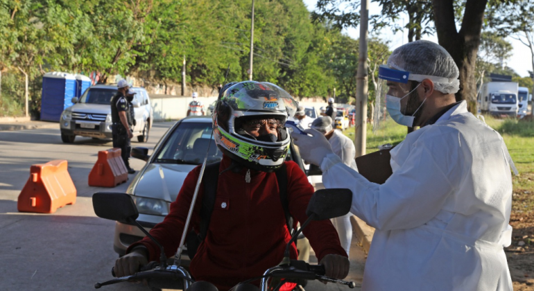 Enfermeiro medindo a temperatura de motociclista