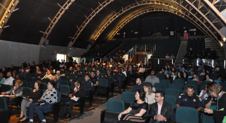 Plateia com mais de trinta pessoas sentadas no interior do Teatro Francisco Nunes, durante o II Seminário Municipal de Prevenção ao Crime e à Violência. 