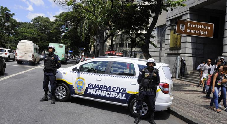 Secretaria de Segurança e Prevenção divulga balanço parcial de ações permanentes desenvolvidas pela Guarda Municipal de Belo Horizonte. Foto: Adão de Souza/PBH Dois guardas municipalis e um carro em frente a Prefeitura Municipal de Belo Horizonte.