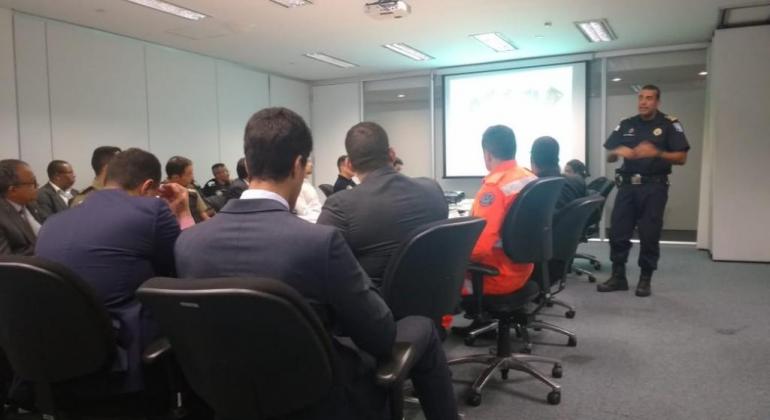 Comandante da Guarda Municipal de BH, Murilo Prates, apresenta Plano de Ação Operacional da Guarda Municipal para o Carnaval em sala da Cidade Administrativa, com cerda de doze pessoas sentadas. 