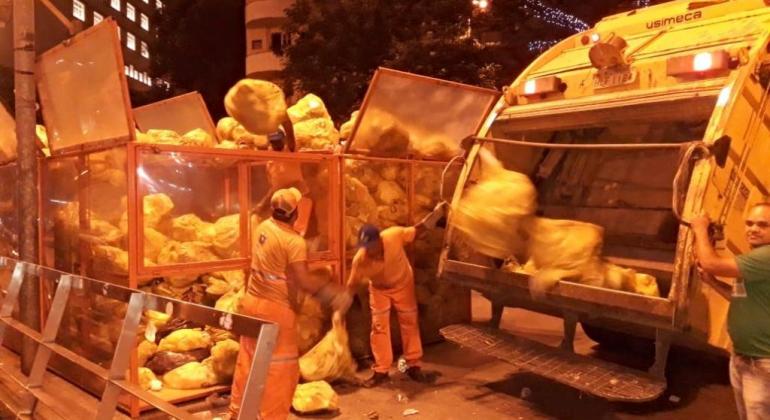 Garis da SLU recolhem lixômetro da Praça Sete, cheio, durante a noite. 