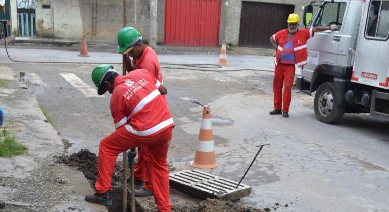 Limpeza e desobstrução de bocas de lobo evitam inundações. Foto: Lidiane Sant'Ana/PBH Profissionais da Limpeza Urbana realizando limpeza de boca de lobo