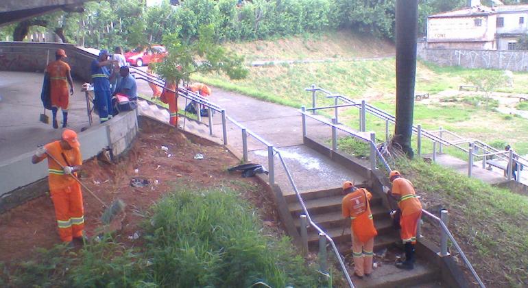 Para garantir a limpeza dos complexos viários de BH, a SLU mantém equipes treinadas para atuar na lavação, na capina e na remoção do lixo. Foto: Divulgação PBH Seis garis da SLU varrem escadaria pública, durante o dia.