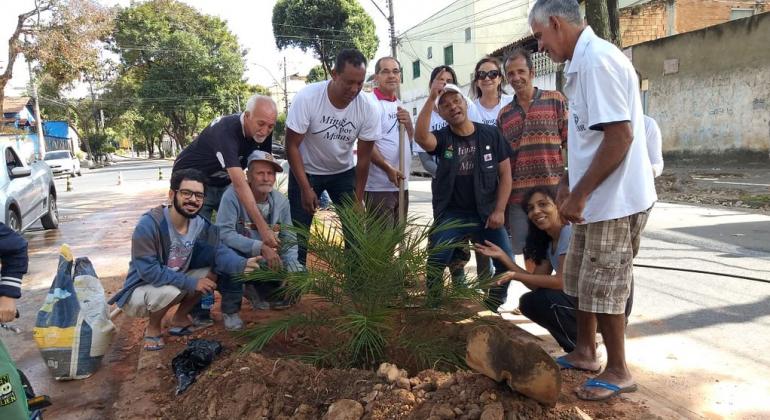 Trabalho é desenvolvido em parceria com a comunidade em toda a cidade e, no último mês, chegou ao bairro Santa Cruz, na região Nordeste. Foto: Divulgação PBH Moradores plantam muda em canteiro que antes era um bota fora de lixo clandestino.