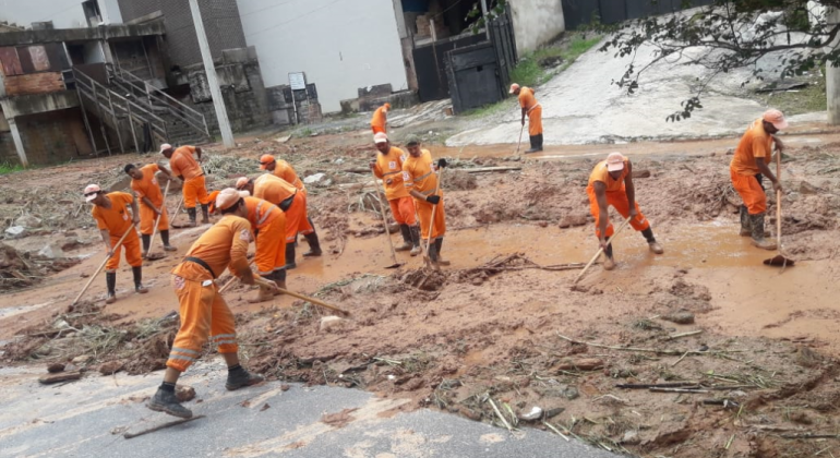 Garis trabalham durante e após a chuva para amenizar efeitos das inundações Garis da Prefeitura limpando vias após inundações
