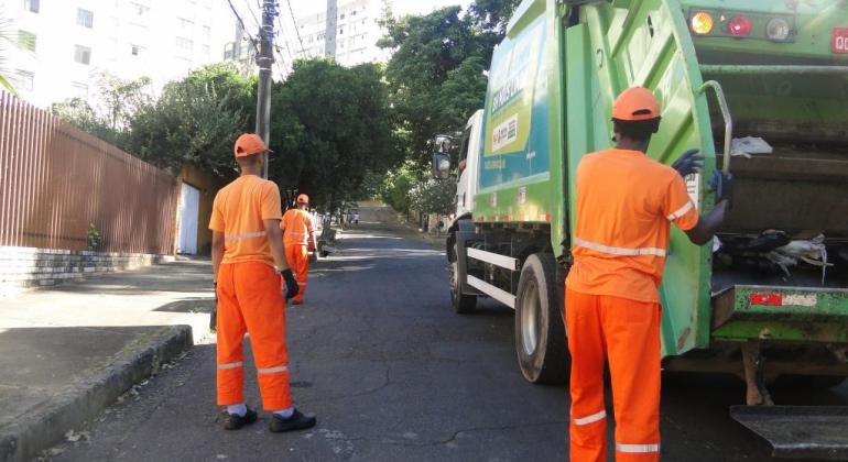 Gari com o caminhão da SLU recolhendo lixo da capital