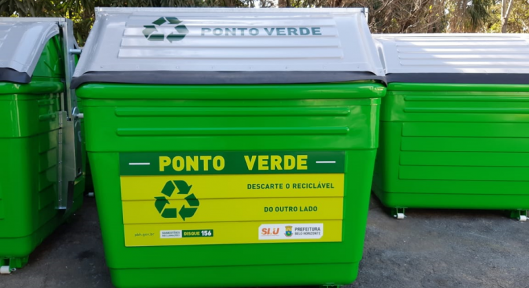 Contêiner verde, escrito "Ponto verde" em amarelo, com tampa cinza clara, em local aberto, durante o dia. 