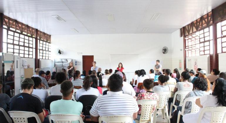 Dezenas de pessoas assistindo aula 