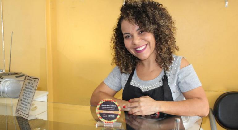 Selo BH Sem racismo visa estimular, apoiar e reconhecer instituições que possuem ações no campo da promoção da igualdade racial. Patrícia Nogueira/PBH Cabelereira mostra o selo BH sem Racismo.