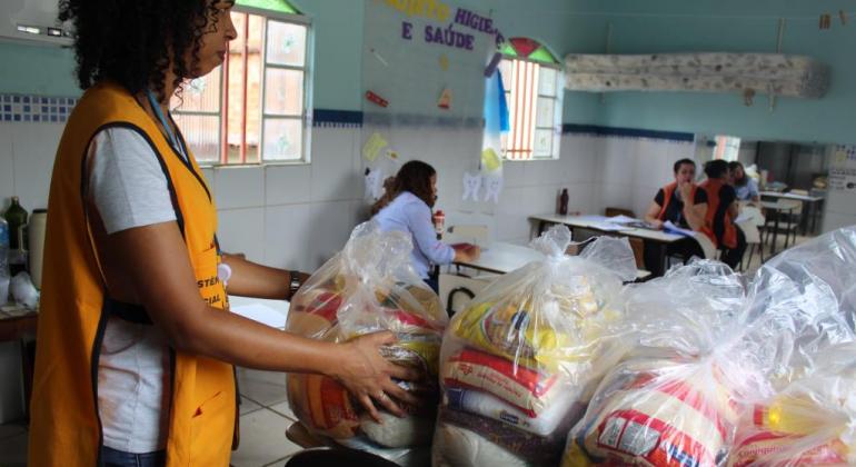 Equipes da Assistência Social distribuindo cestas básicas na Vila Bernadete, no Barreiro