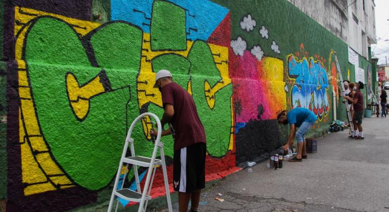 Muro do CRAS Vila Antena ganha vida após intervenção artística Imagem do muro do CRAS sendo grafitado
