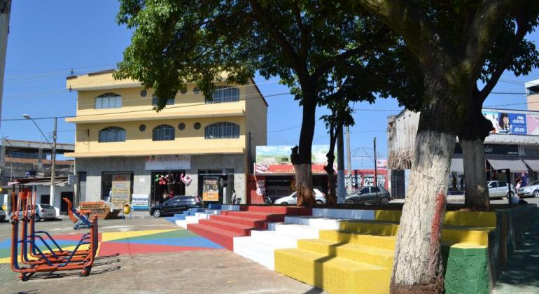 Praça limpa e conservada, durante o dia. 