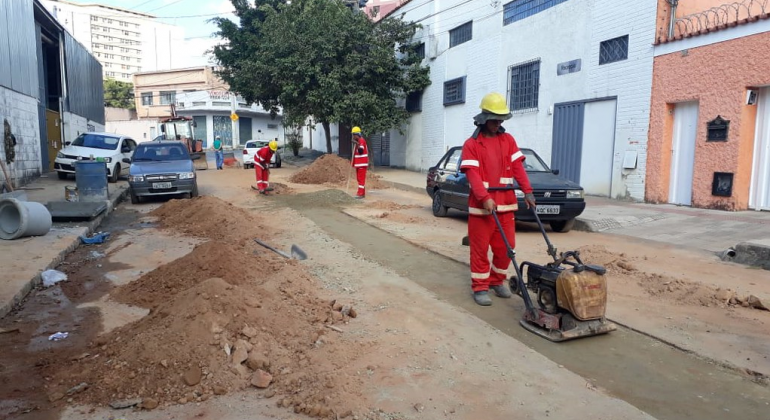 O trecho sem saída da rua Nova Friburgo recebeu ações para evitar inundações nos períodos de chuva, numa obra de cerca de R$ 40 mil. Foto: Lilian Lopes/PBH Três homens pavimentam a rua nova Friburgo, durante o dia.