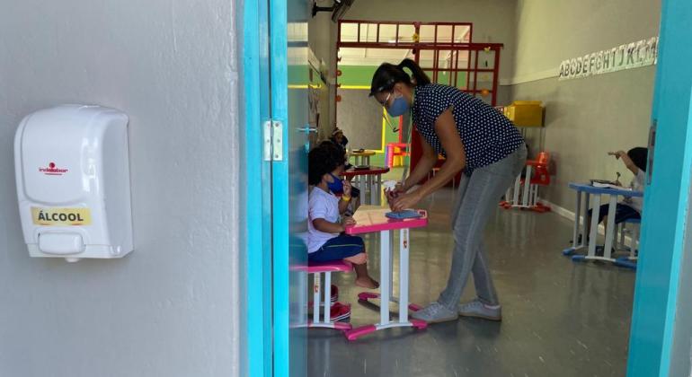 Professora interagindo com criança em sala de aula