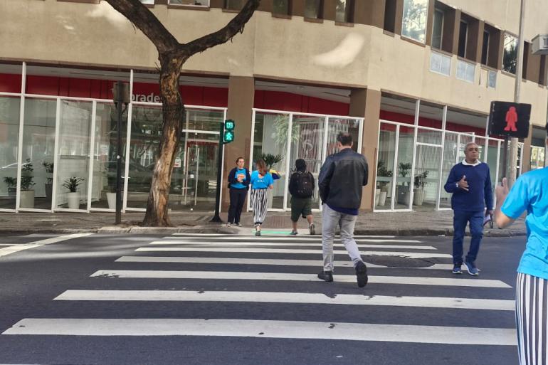 PBH amplia teste para segurança nas travessias de pedestres Pedestres atravessam a via na faixa de pedestres com o sinal verde.