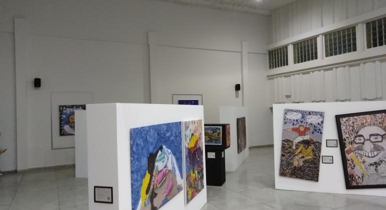 Projeto Arte e Sustentabilidade a imagem mostra uma sala onde se vê quadros expostos em 1º e 2º planos, cerca de oito obras de arte .