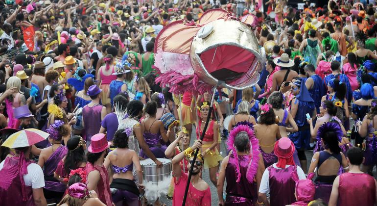 A imagem mostra foliões em um bloco de Carnaval, em Belo Horizonte