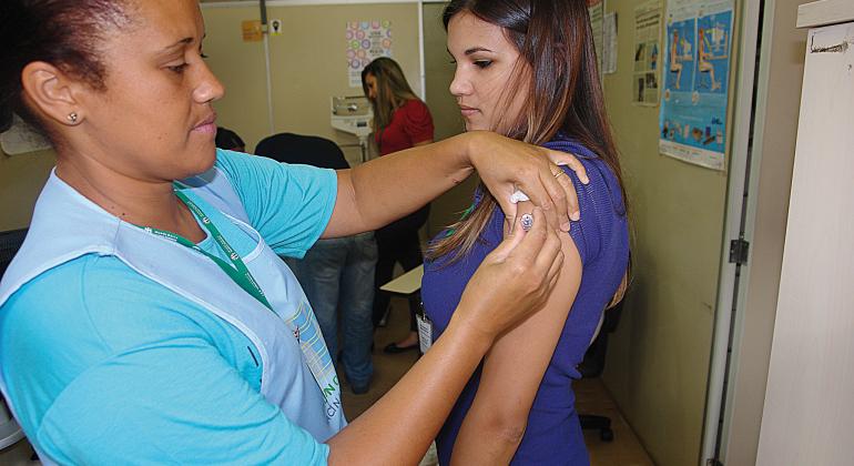 Funcionária de um posto de saúde aplica vacina contra febre amarela em uma mulher. Foto: Divulgação