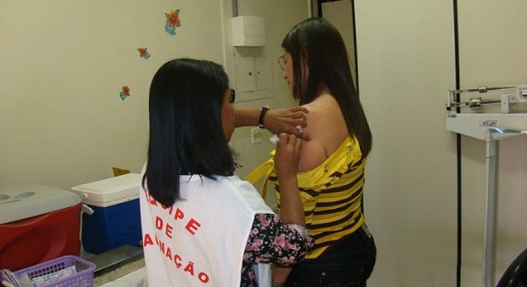 Prefeitura já vacinou 620 mil pessoas contra febre amarela Agente de saúde vacina ombro de cidadã. Foto: Divulgação PBH