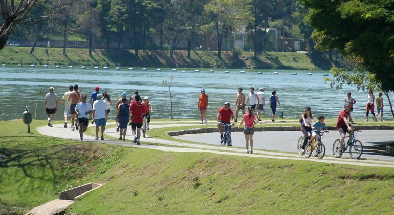 Pessoas camnhando e pedalando na orla da Lagoa da Pampulha