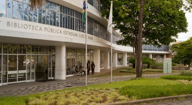 Biblioteca Pública Estadual Luiz de Bessa Foto da entrada da prefeitura. Tem uma árvore, um canteiro gramado na frente da biblioteca.