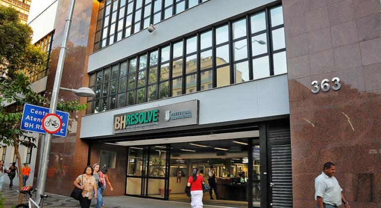 Confira vagas de emprego oferecidas nos postos do Sine. Foto: Isabel Baldoni Fachada do BH Resolve, no Centro, com pessoas passando, de dia.