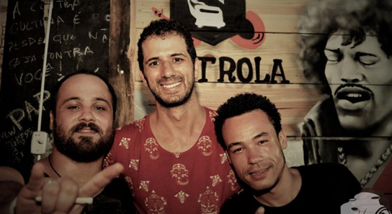 Três homens, membros da banda Nagori, sorriem. Foto: Felipe Perry