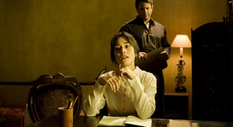 Homem em pé olha mulher sentada em mesa em sala com decoração e figurino antigos: cena do filme "A erva do rato", de Julio Bressane (2008). Foto: Divulgação MIS Cine Santa Teresa faz mostra sobre cinema nacional