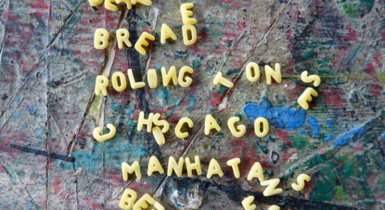 Trabalho de portador de sofrimento mental tem fundo colorido sob letras amarelas, soltas, que formam palavras como Beatles, bread, Roling Tones e Manhatan misturados a letras desconexas.