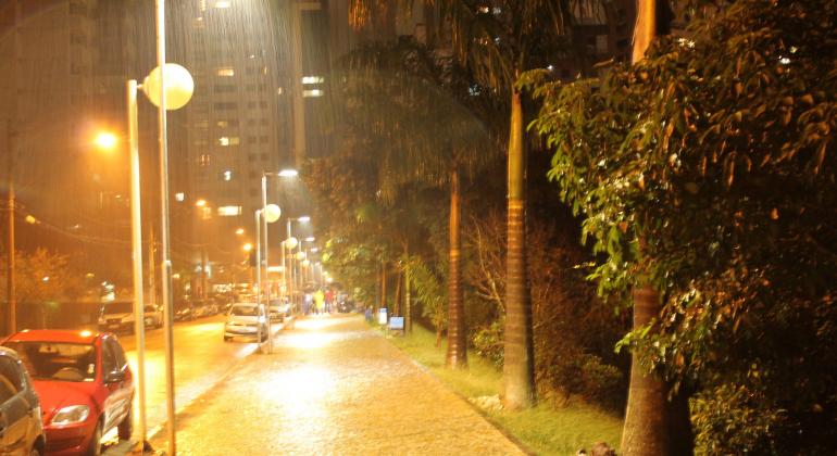 Rua iluminada em dia de chuva