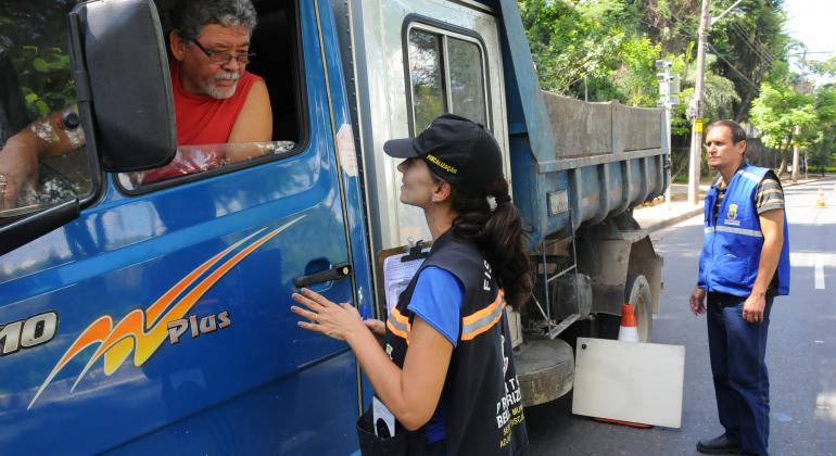 Fiscais da Prefeitura de Belo Horizonte conversam com motorista de caminhão em blitz da Operação Oxigênio