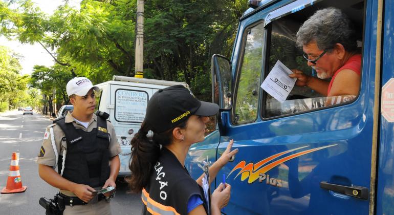 PBH alerta sobre o combate à poluição veicular em blitz - Foto: Breno Pataro Fiscal da Prefeitura de Belo Horizonte e policiam militar conversam com motorista de caminhão em blitz da Operação Oxigênio