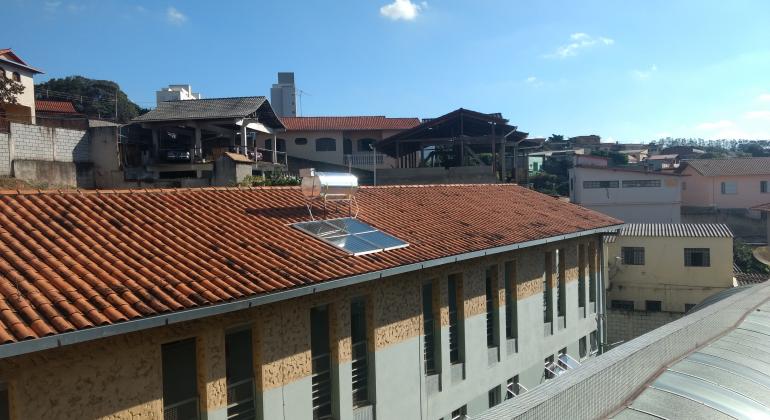 Foto do telhado da Escola Municipal Dom Bosco com placas de aquecimento solar. 