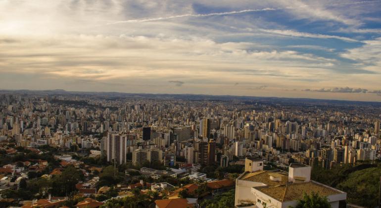 Vista da cidade de Belo Horizonte com céu azul e nuvens durante o dia.