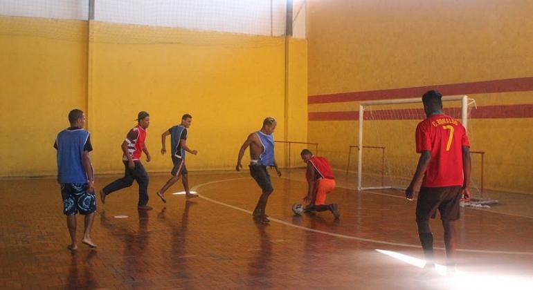 Seis cidadãos em situação de vida nas ruas jogam futebol de salão. 