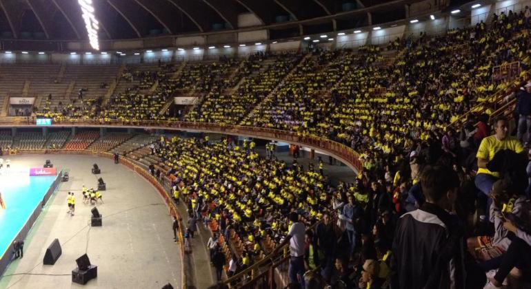 Na semana em que se comemora o dia nacional do vôlei, mais de 1200 crianças, jovens e adultos de 29 escolas da Rede Municipal de Educação tiveram a chance de acompanhar um jogo da Seleção Brasileira de Vôlei Feminino. Foto: Déborah Corsino A foto mostra o estádio do Mineirinho, com um lado das arquibancadas tomado por torcedores(crianças e alunos da Eja) vestindo a camisa amarela da seleção