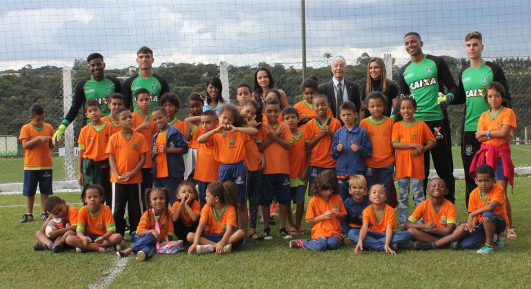 Alunos da Escola Municipal Itamar Franco posam ao lado de goleiros do América, time de futebol de Belo Horizonte