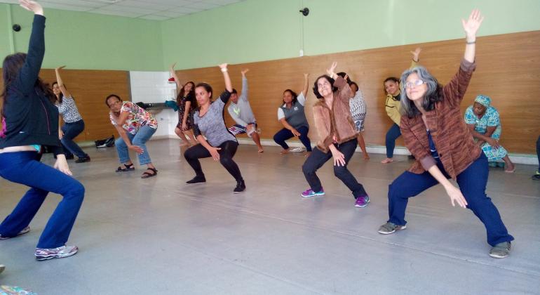 Turma de mais de nove cidadãos fazendo aula de Lian Gong