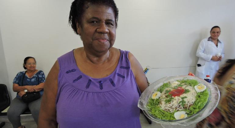 Mulher segura prato de salada