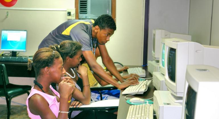 Jovens em vulnerabilidade social, qualificados pelo Programa BH Digital, serão selecionados para atuarem como monitores de informática.Foto: Prodabel/PBH Monitor da Prodabel auxilia duas jovens em atividades de informática