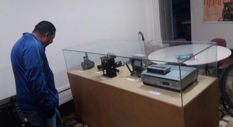 Programa Circuito de Museus fecha o primeiro semestre com mais de 12 mil alunos participantes. Foto: Smed/PBH Aluno olhando para equipamentos de som em uma vitrine de vidro em uma sala de museu.