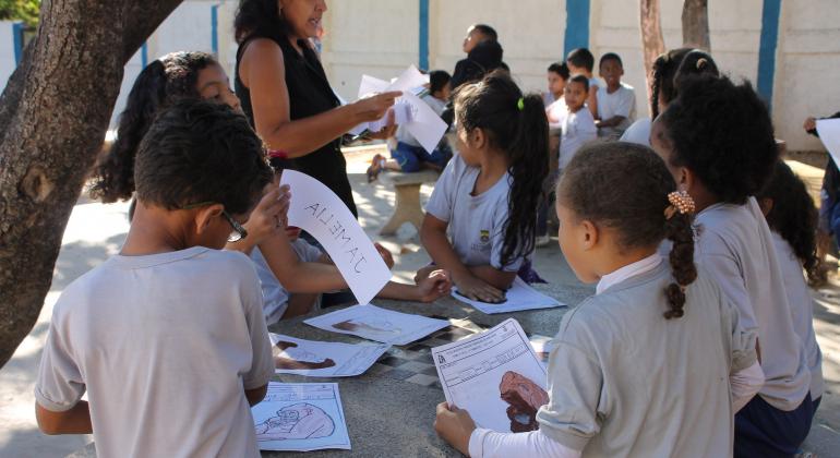 Seis alunos da Rede Muicipal de Ensino fazem deselhos sobre o novo golrilinha do Zoológico, acompanhados por educadora infantil.