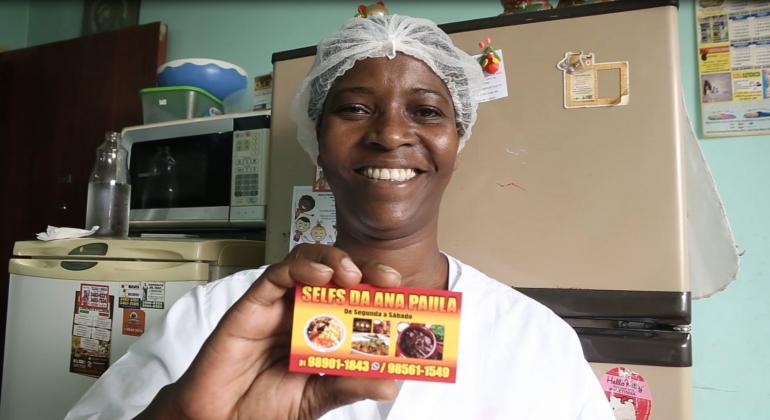 Projeto BH Negócios promove inclusão produtiva e empreendedorismo em áreas de vulnerabilidade social. Foto: Divulgação PBH Ana Paula Nunes Ferreira sorri e mostra o cartão do serviço de alimentação que montou com ajuda do projeto BH Negócios.