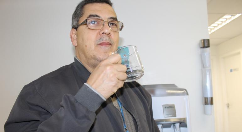 Campanha permanente para gerar redução nos gastos públicos tem até competição promovida pelos próprios servidores da PBH. Foto: Aline Pereira/PBH O agente público Ricardo Amora bebe água com caneca própria, evitando o uso de copos descartáveis.