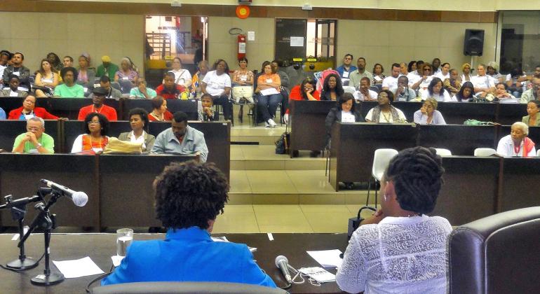 Evento marca os 19 anos de instituição das políticas de enfrentamento ao racismo e de promoção da igualdade racial na cidade. Foto: SMPS/PBH Autoridades ligadas à Promoção da Igualdade Racial realizam palestra para plateia em auditório. Foto ilustrativa.