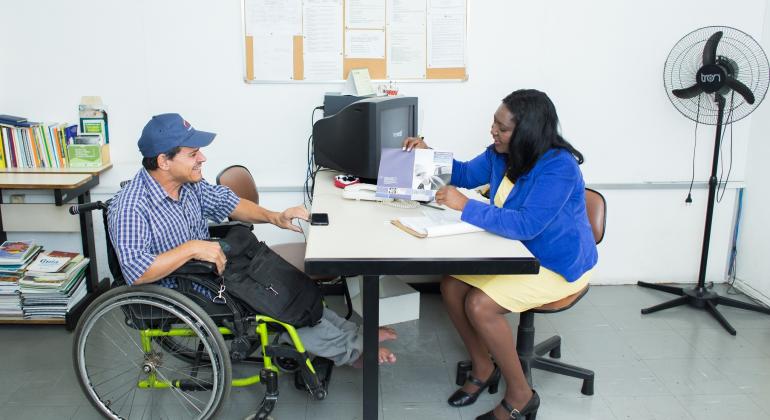 Cadeirante é atendido por integrante do Projeto de Mercado de Trabalho Inclusivo