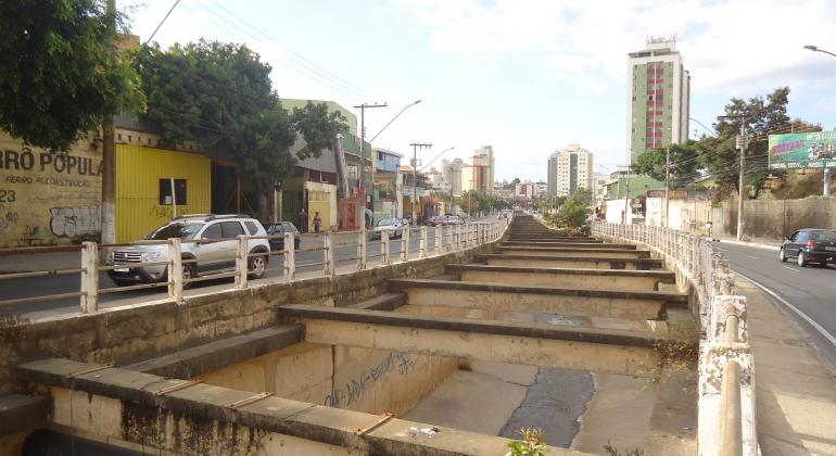 Foto de rio parte da bacia do Córrego Cachoeirinha em área urbana, canalizado, durante o dia.