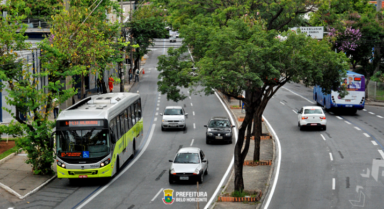 Carros e ônibus trafegam nas pistas da Avenida Antônio Carlos, durante o dia.