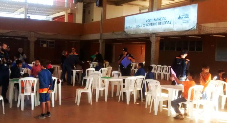 Oficina de Pipas promovida pela Guarda Municipal resgata tradição e alerta para os perigos do uso do cerol ou linha chilena. Foto: Segurança Urbana/PBH Três Guardas Municipais ministram Oficina de Pipas a cerca de cinco crianças.