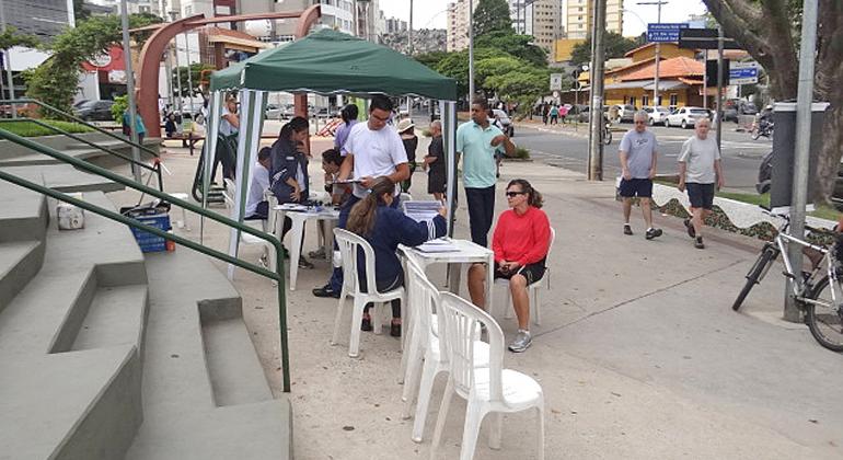 Cidadãos realizam exame em estande do Projeto caminhar durante o dia.